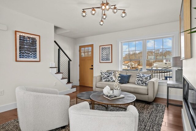 living room with dark hardwood / wood-style flooring, a chandelier, and plenty of natural light