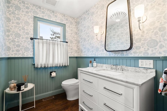 77 Lighthouse Rd, Scituate, MA 02066 - bathroom with wood finished floors, a wainscoted wall, vanity, wallpapered walls, and toilet