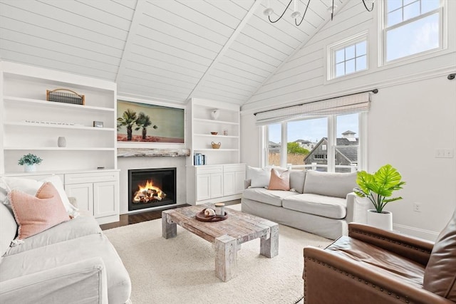 77 Lighthouse Rd, Scituate, MA 02066 - living room with built in shelves, high vaulted ceiling, a lit fireplace, wood ceiling, and wood finished floors