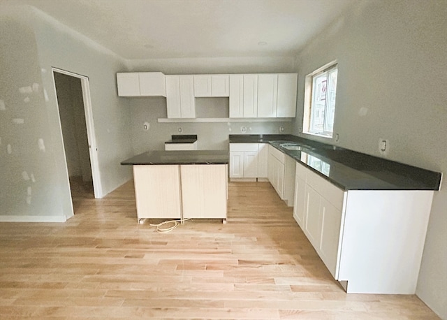 kitchen with light hardwood / wood-style flooring, white cabinets, and a center island