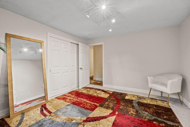 living area featuring carpet and baseboards