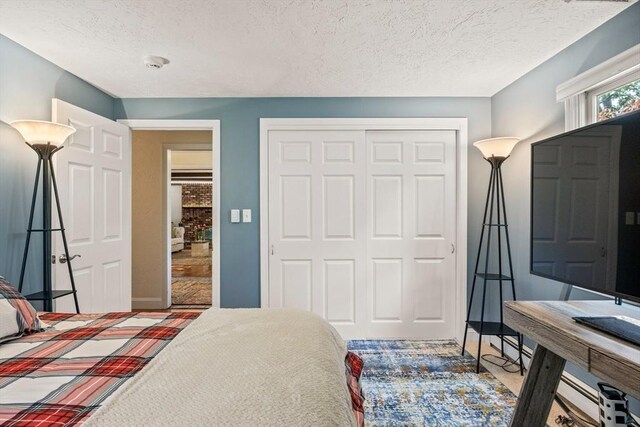 bedroom featuring a textured ceiling, a closet, and baseboards