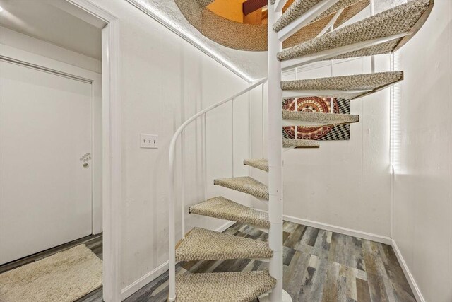 staircase with baseboards and wood finished floors