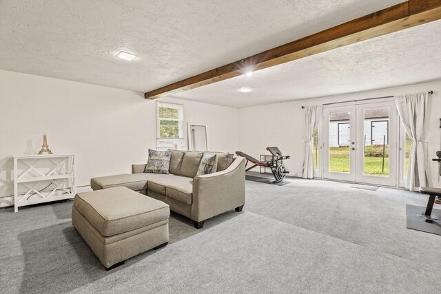 living area with a textured ceiling, french doors, carpet flooring, and beamed ceiling