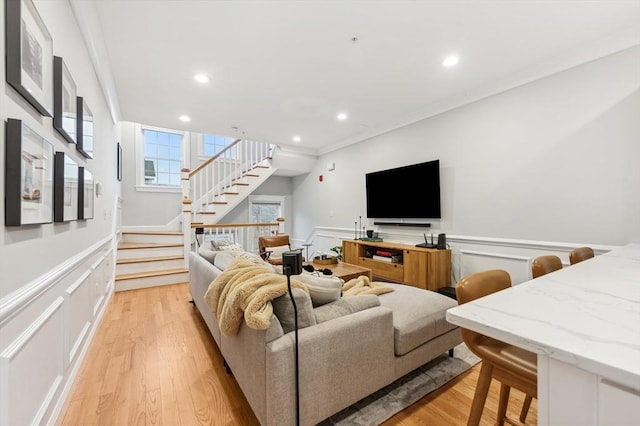 living room with ornamental molding and light hardwood / wood-style floors