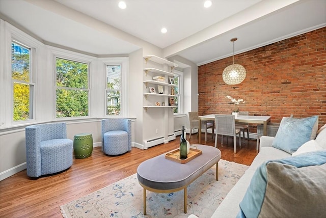 living room featuring hardwood / wood-style flooring, a baseboard radiator, beamed ceiling, and brick wall