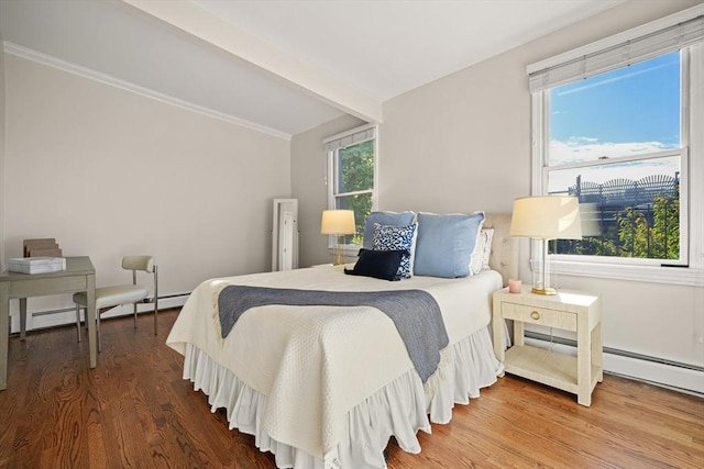 bedroom with beam ceiling, a baseboard heating unit, and hardwood / wood-style flooring