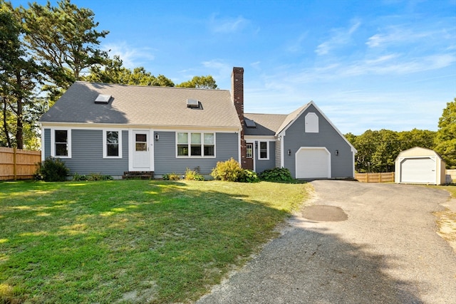 view of front of house featuring an outbuilding, a garage, and a front lawn