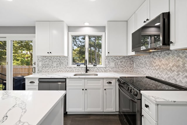 kitchen with a healthy amount of sunlight, black appliances, white cabinets, and sink