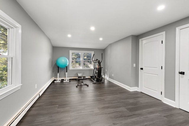 exercise area with a baseboard heating unit and dark hardwood / wood-style flooring