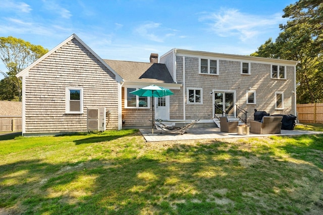 rear view of property featuring a patio area and a lawn