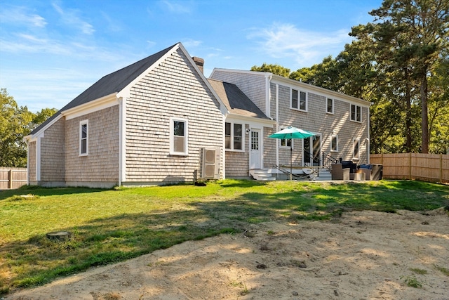 rear view of property featuring a yard and a patio area