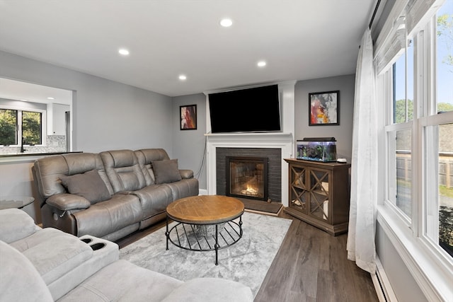 living room featuring hardwood / wood-style floors and a brick fireplace