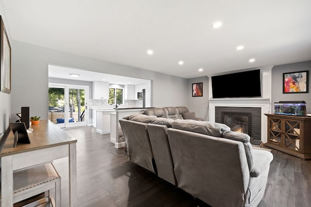 living room with a brick fireplace and wood-type flooring