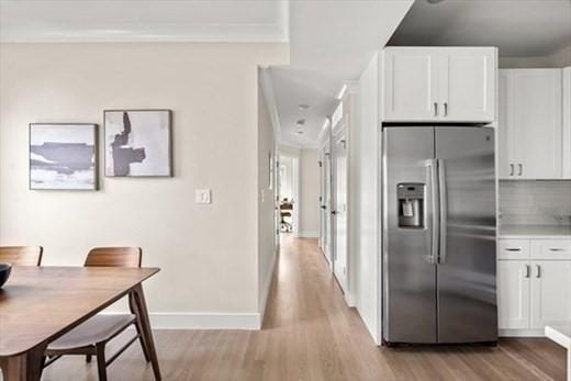 303 Maverick St Ph, Ph, Boston, MA 02128 - kitchen featuring stainless steel fridge with ice dispenser, light wood-style flooring, tasteful backsplash, white cabinetry, and baseboards