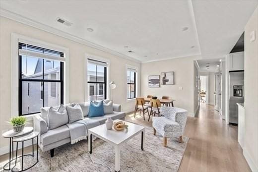 303 Maverick St Ph, Ph, Boston, MA 02128 - living area with visible vents, baseboards, crown molding, and wood finished floors