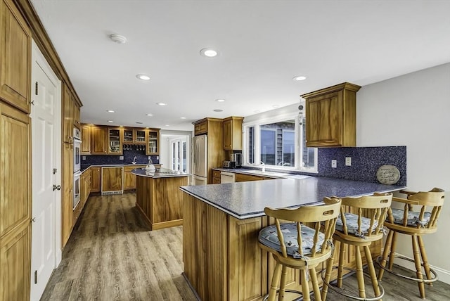 31 Baxendale Rd, Bourne, MA 02532 - kitchen with dark wood-style flooring, recessed lighting, a peninsula, decorative backsplash, and appliances with stainless steel finishes