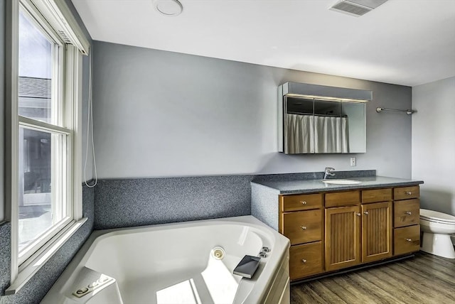31 Baxendale Rd, Bourne, MA 02532 - bathroom with visible vents, toilet, a whirlpool tub, vanity, and wood finished floors