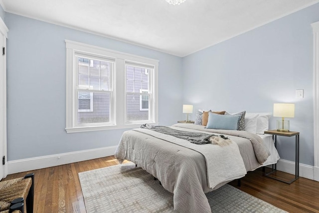 bedroom with baseboards and wood finished floors