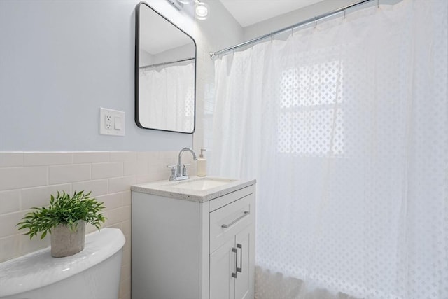 full bathroom featuring vanity, a shower with curtain, toilet, and tile walls
