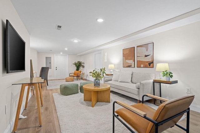 living area with recessed lighting, baseboards, visible vents, and light wood-style flooring