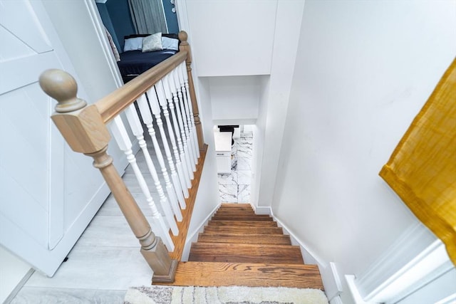 stairway featuring baseboards and wood finished floors