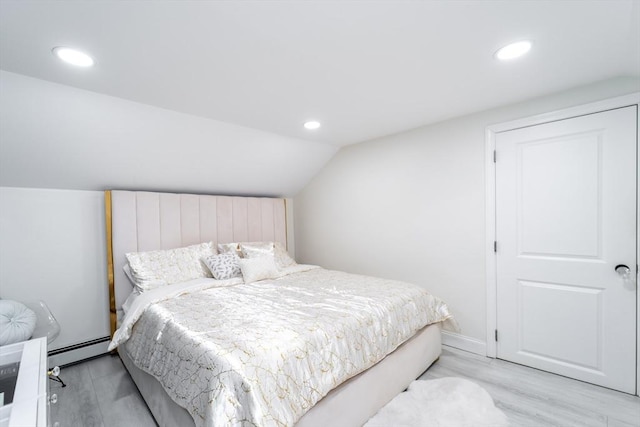 bedroom featuring a baseboard heating unit, vaulted ceiling, wood finished floors, and recessed lighting