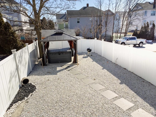 view of yard featuring a hot tub and a fenced backyard