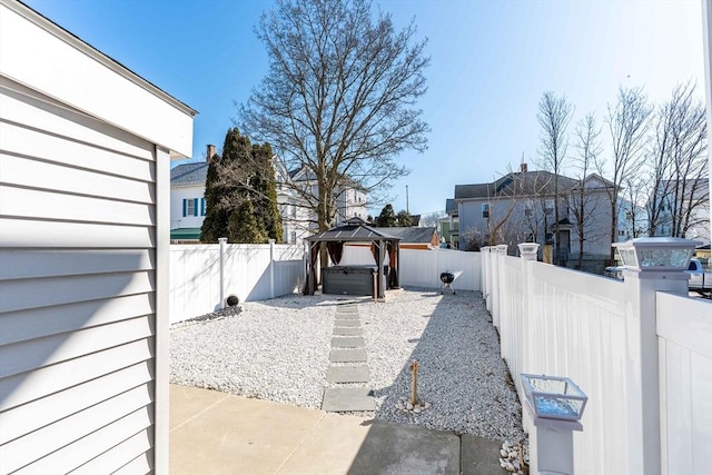 view of yard featuring a fenced backyard, a patio, a hot tub, and a gazebo