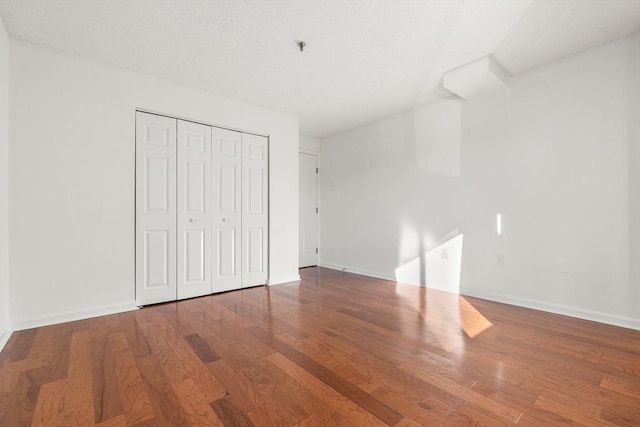 unfurnished bedroom featuring hardwood / wood-style floors and a closet