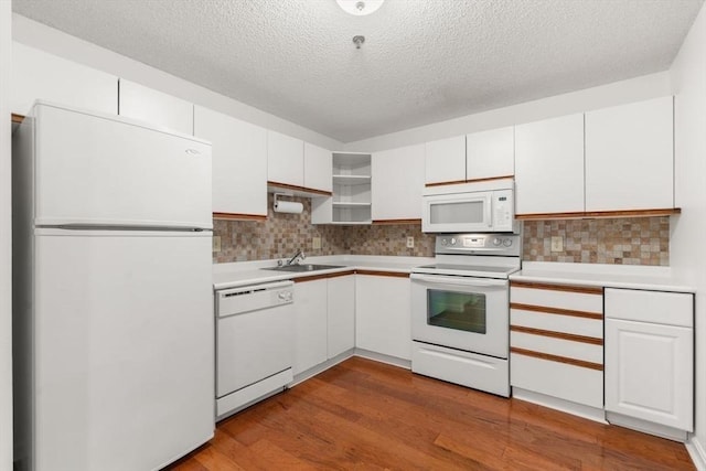 kitchen with sink, white cabinets, white appliances, and light hardwood / wood-style floors