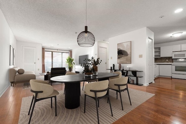 dining room featuring hardwood / wood-style flooring and a textured ceiling