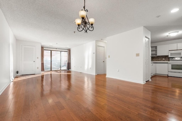 unfurnished living room with wood-type flooring, a chandelier, and a textured ceiling