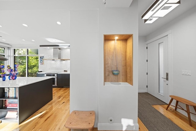 137 Walden St Unit 137, Cambridge, MA 02140 - kitchen featuring wall chimney range hood, oven, light wood finished floors, recessed lighting, and light countertops