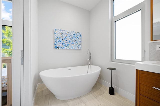 137 Walden St Unit 137, Cambridge, MA 02140 - bathroom featuring a freestanding tub, vanity, and plenty of natural light