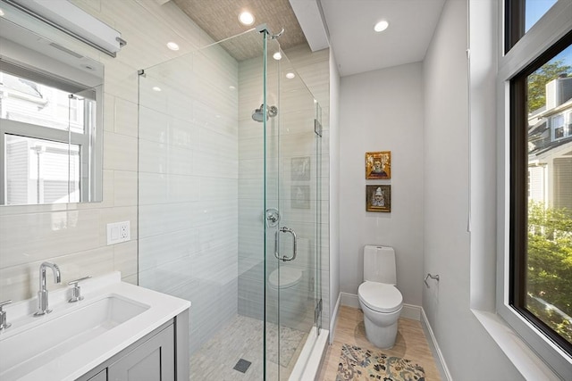 137 Walden St Unit 137, Cambridge, MA 02140 - bathroom featuring toilet, vanity, plenty of natural light, a shower stall, and recessed lighting