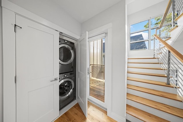 137 Walden St Unit 137, Cambridge, MA 02140 - washroom with stacked washer / drying machine, light wood-style flooring, and baseboards