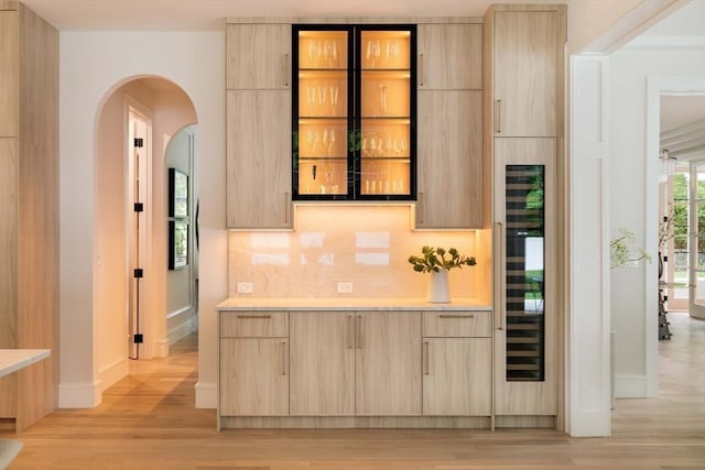 95 Blake St, Newton, MA 02460 - indoor dry bar with light wood-type flooring, tasteful backsplash, baseboards, and arched walkways