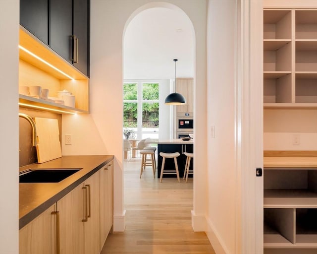 95 Blake St, Newton, MA 02460 - hall with a sink, light wood-style flooring, arched walkways, and baseboards