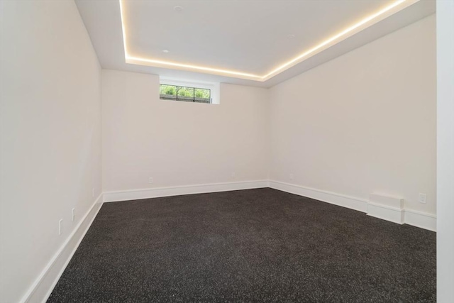 95 Blake St, Newton, MA 02460 - empty room featuring baseboards, a tray ceiling, and dark colored carpet