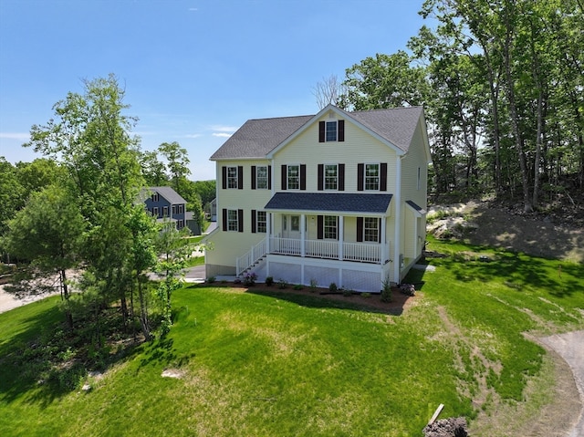 rear view of property featuring a lawn and covered porch