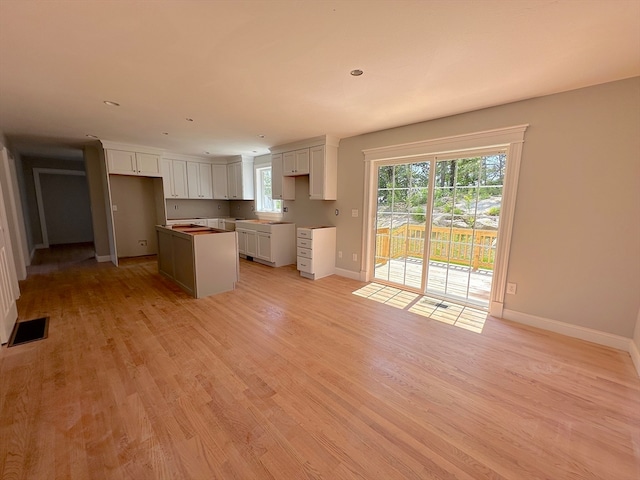 kitchen featuring light wood-type flooring, a center island, and white cabinetry