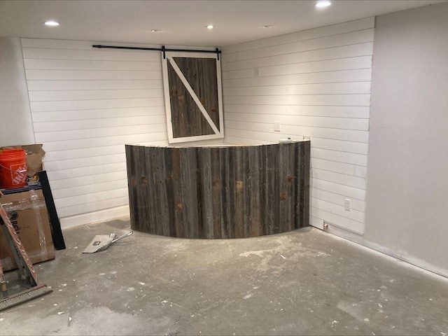 337 Mason Rd, Dudley, MA 01571 - spare room with a barn door, recessed lighting, wooden walls, and unfinished concrete floors