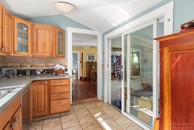 11 Hickory St, Gloucester, MA 01930 - kitchen featuring vaulted ceiling, glass insert cabinets, backsplash, light marble finish floors, and stainless steel dishwasher