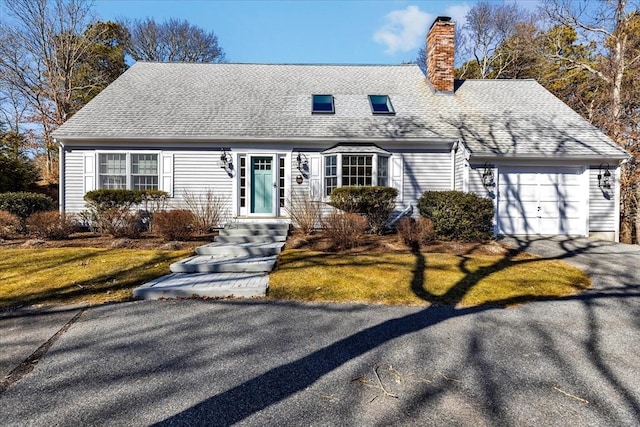 new england style home with aphalt driveway, a chimney, a garage, and roof with shingles