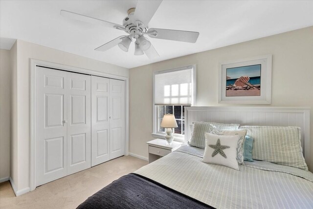 bedroom featuring baseboards, a ceiling fan, a closet, and light carpet