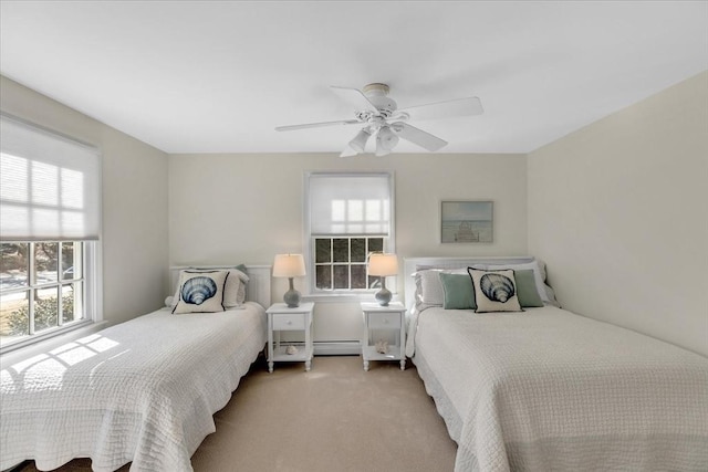 carpeted bedroom with a baseboard heating unit and a ceiling fan