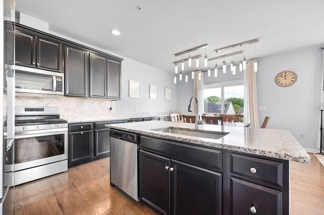 19 Locust Ln Unit 19, Hopkinton, MA 01748 - kitchen featuring appliances with stainless steel finishes, a sink, dark cabinetry, light wood finished floors, and recessed lighting