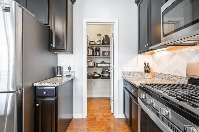 19 Locust Ln Unit 19, Hopkinton, MA 01748 - kitchen with appliances with stainless steel finishes, light stone counters, and light wood-style floors