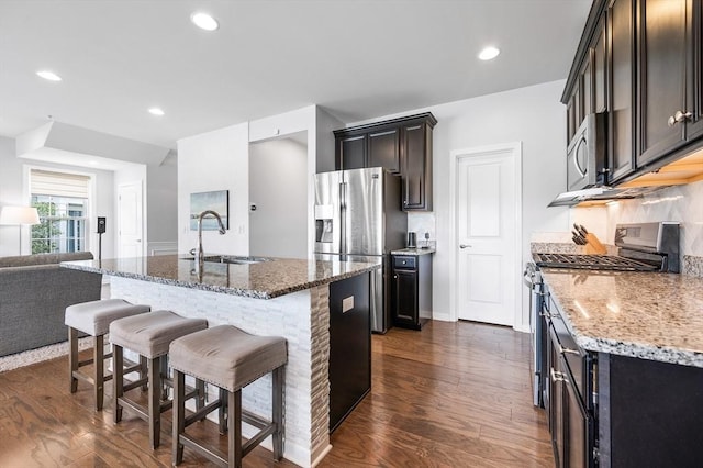 19 Locust Ln Unit 19, Hopkinton, MA 01748 - kitchen featuring appliances with stainless steel finishes, a sink, light stone counters, a kitchen bar, and dark wood-style flooring